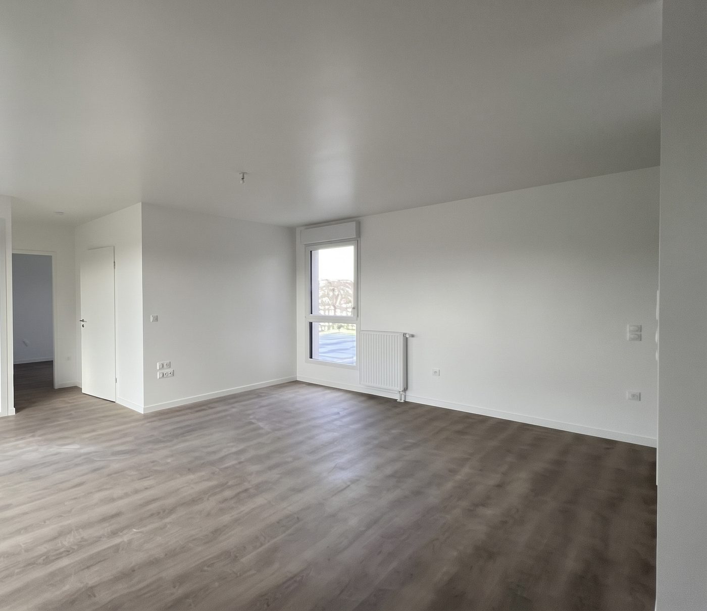 Mortcerf, séjour d'un logement terminé avec parquet et fenêtre