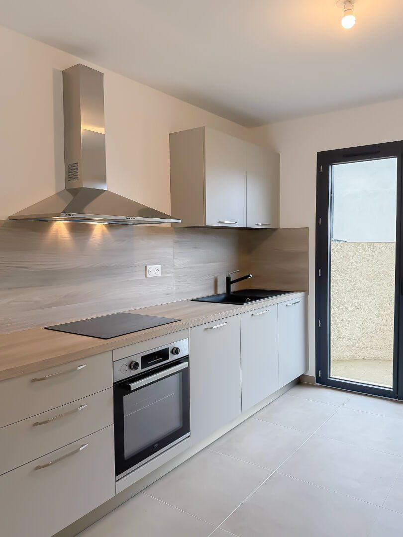 Presles, cuisine équipée d'un logement avec porte-fenêtre